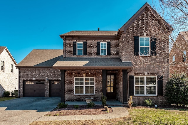 traditional-style house featuring aphalt driveway, a porch, a garage, a shingled roof, and brick siding