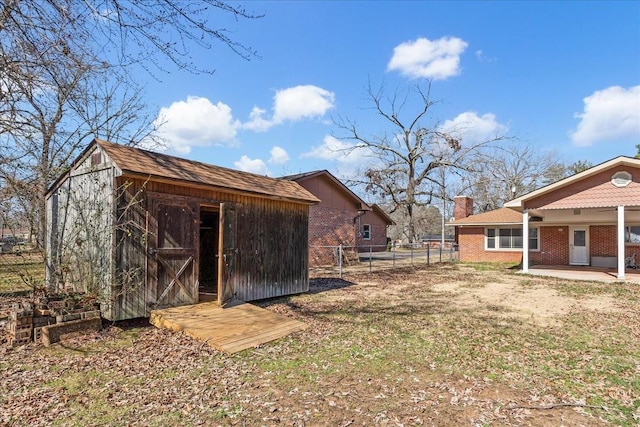 view of yard with an outbuilding, fence, a storage shed, and a patio