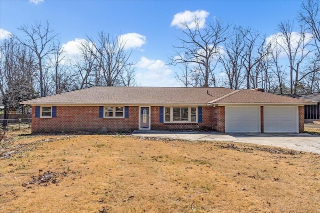 single story home with driveway, brick siding, an attached garage, and a front yard