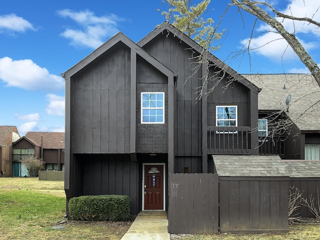 view of front of house with roof with shingles and a front lawn