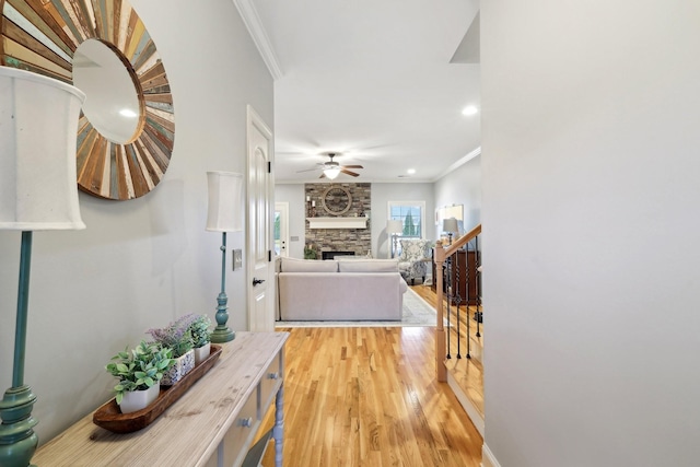 hall featuring ornamental molding, light wood finished floors, and stairs