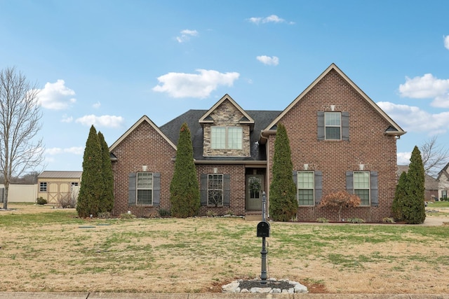 traditional-style house with stone siding, a front yard, and brick siding