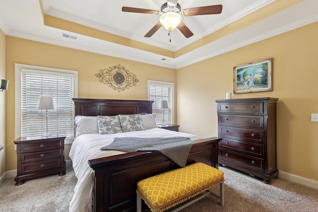 bedroom featuring a tray ceiling, crown molding, visible vents, light carpet, and baseboards