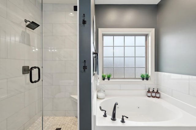 bathroom featuring a garden tub and a shower stall