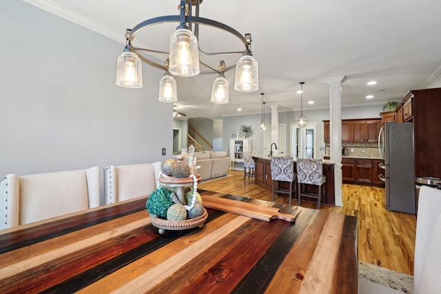 dining space with recessed lighting, crown molding, ornate columns, and wood finished floors