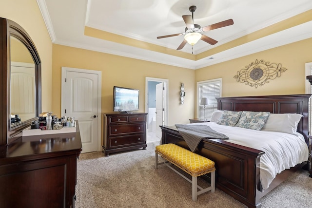 bedroom with ornamental molding, a tray ceiling, light colored carpet, and visible vents