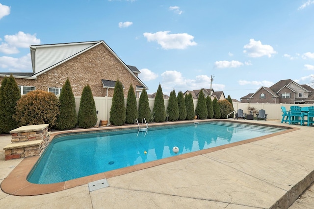 view of swimming pool featuring a fenced in pool, fence private yard, a patio, and a residential view