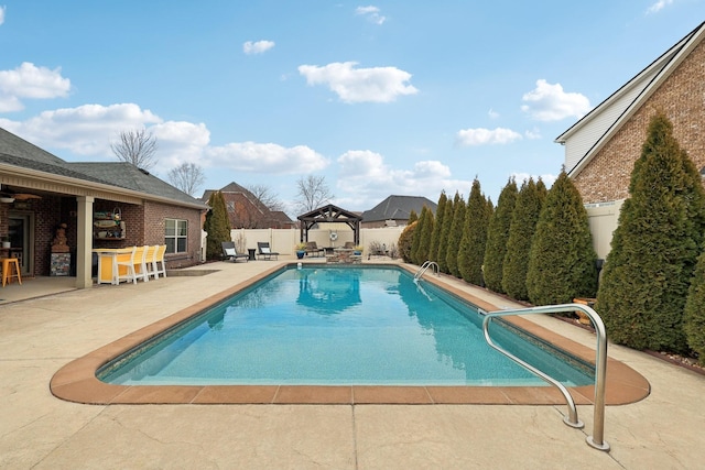 view of swimming pool with a fenced in pool, a patio, a fenced backyard, outdoor dry bar, and a gazebo