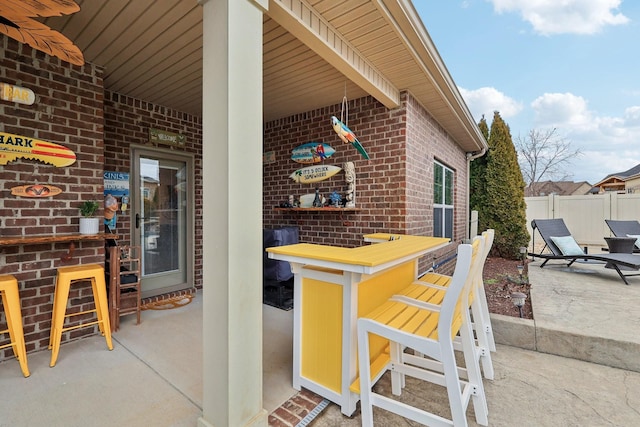 view of patio featuring fence and outdoor dry bar