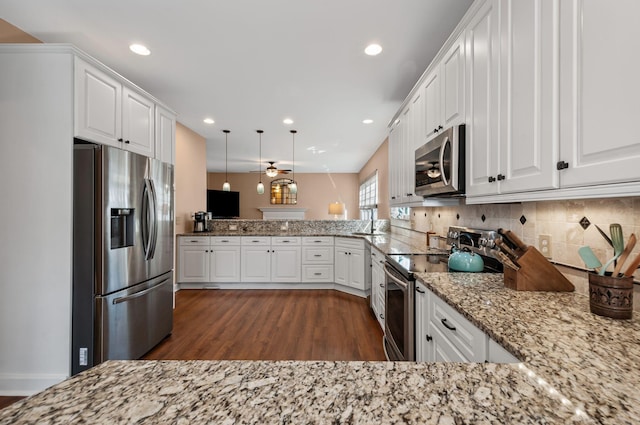 kitchen with stainless steel appliances, pendant lighting, white cabinetry, and a peninsula