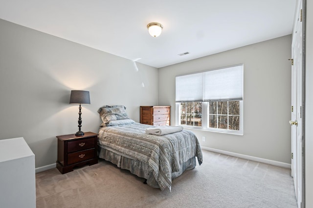 bedroom with baseboards, visible vents, and light colored carpet