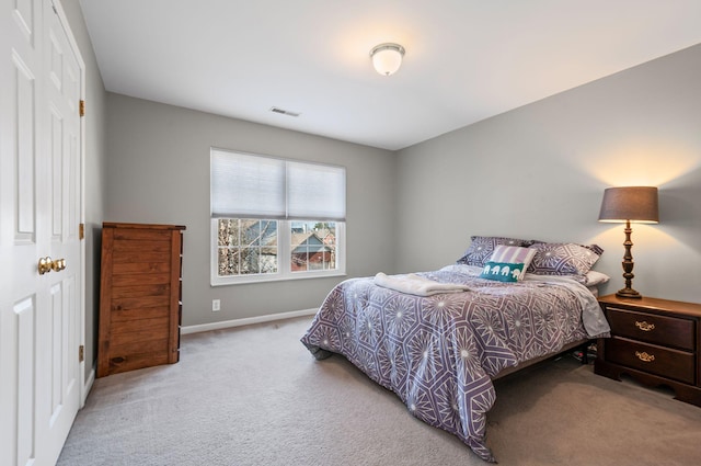 bedroom with light colored carpet, visible vents, and baseboards