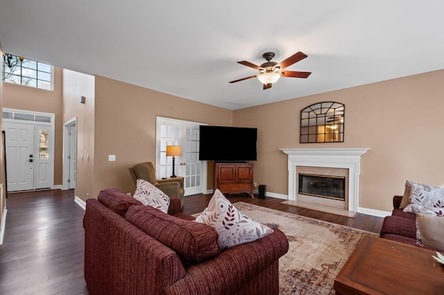 living room featuring a ceiling fan, dark wood-style flooring, and baseboards