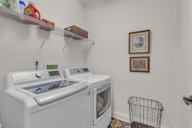 clothes washing area featuring laundry area, washing machine and dryer, and baseboards