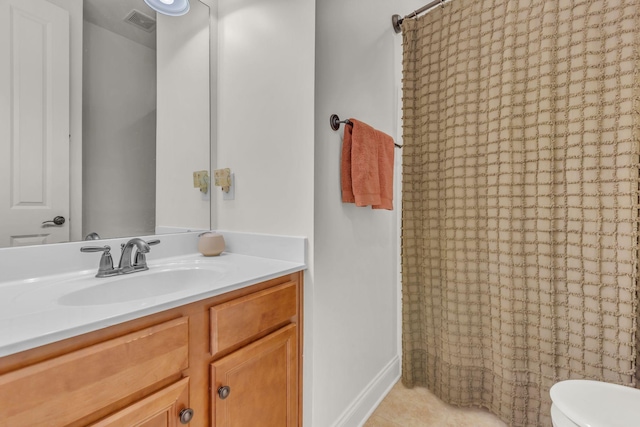 bathroom with tile patterned flooring, toilet, vanity, visible vents, and baseboards