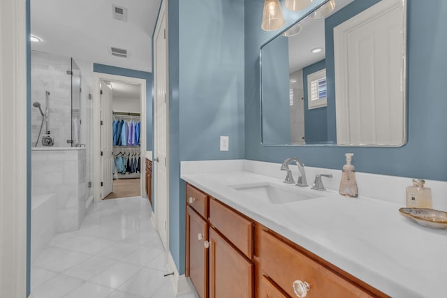 bathroom with a walk in closet, visible vents, a shower stall, and vanity