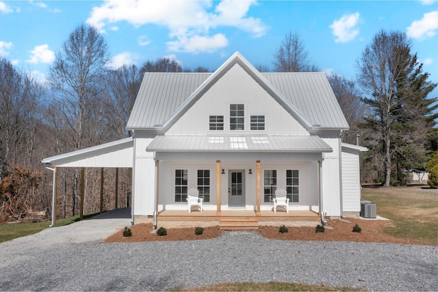 modern farmhouse featuring driveway, metal roof, a porch, and an attached carport