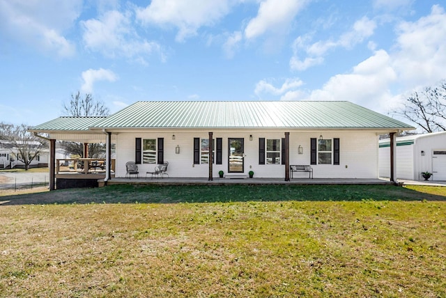 view of front of home featuring a front yard, metal roof, and fence