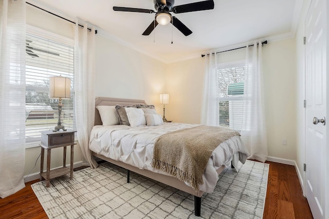 bedroom with crown molding, baseboards, ceiling fan, and wood finished floors