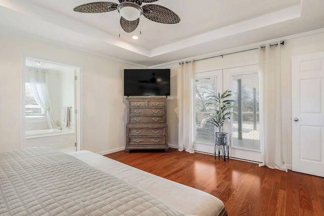 bedroom with multiple windows, access to outside, a tray ceiling, and dark wood-style flooring