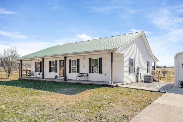 ranch-style house with metal roof, a porch, a front lawn, and cooling unit