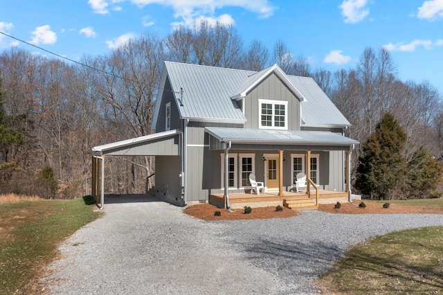 view of front of home featuring metal roof, gravel driveway, a carport, a porch, and board and batten siding