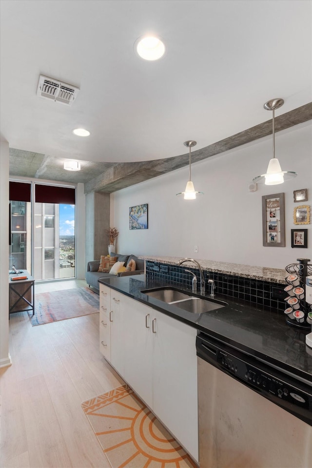 kitchen with visible vents, hanging light fixtures, white cabinetry, a sink, and dishwasher