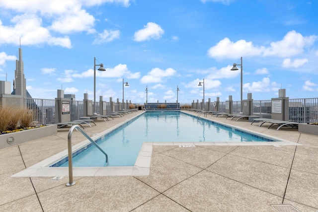 pool with a patio and fence