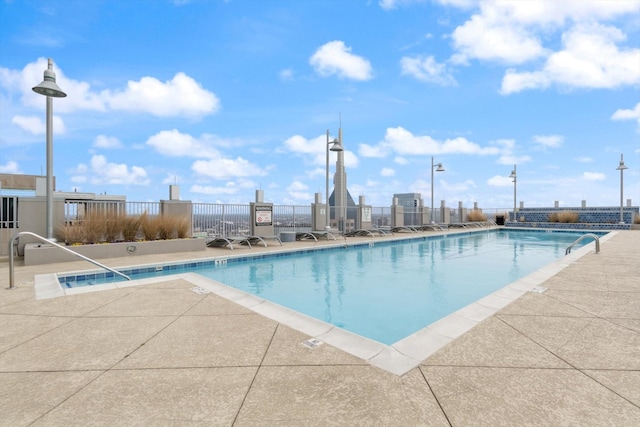 community pool featuring fence and a patio