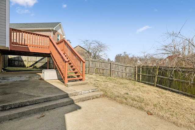 view of yard with a patio area, a fenced backyard, stairs, and a deck