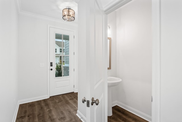 doorway to outside featuring dark wood-style floors, a notable chandelier, ornamental molding, and baseboards