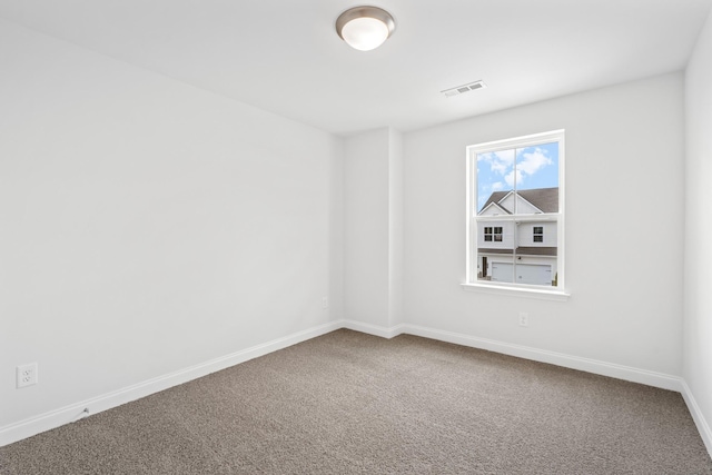 empty room featuring carpet floors, visible vents, and baseboards