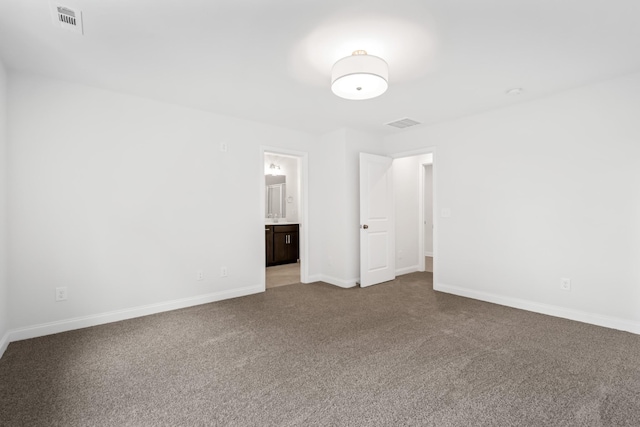 unfurnished bedroom with carpet, visible vents, baseboards, and ensuite bathroom