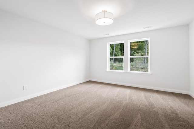 spare room featuring baseboards and carpet flooring