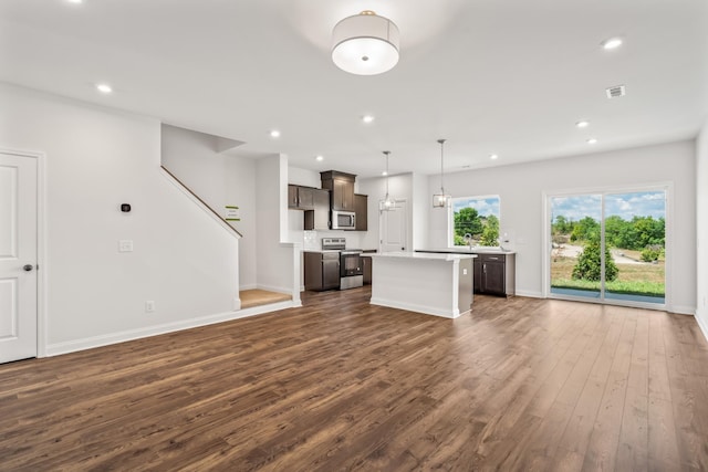 unfurnished living room featuring dark wood-style flooring, recessed lighting, visible vents, stairway, and baseboards