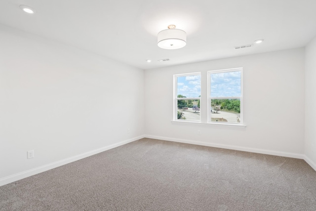 spare room featuring recessed lighting, carpet, visible vents, and baseboards