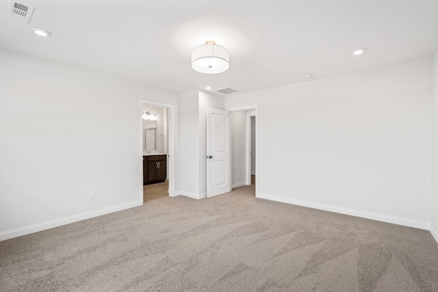 unfurnished bedroom featuring visible vents, light carpet, and baseboards