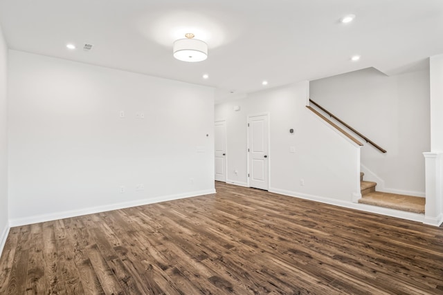 unfurnished living room with stairs, dark wood finished floors, and recessed lighting