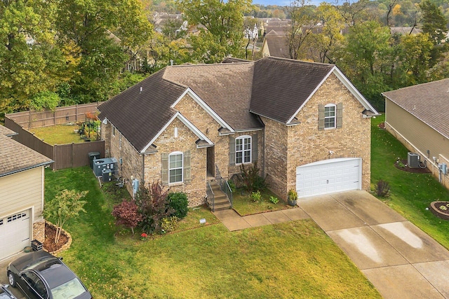 view of front of property with cooling unit, brick siding, fence, concrete driveway, and a front lawn