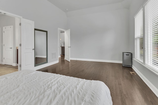 bedroom featuring high vaulted ceiling, dark wood finished floors, visible vents, and baseboards