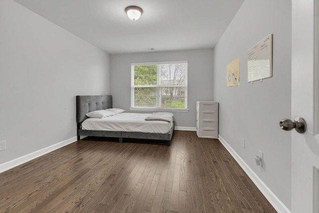 bedroom featuring visible vents, baseboards, and dark wood finished floors