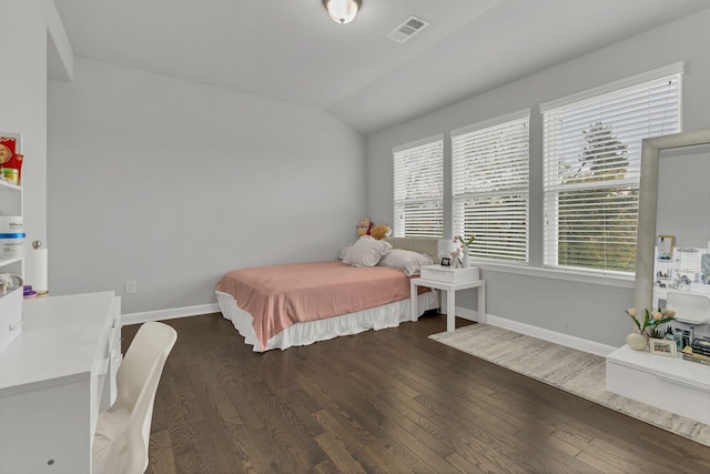 bedroom featuring dark wood-style floors, lofted ceiling, and visible vents