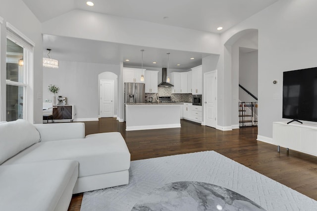 living area featuring arched walkways, recessed lighting, dark wood-style flooring, baseboards, and vaulted ceiling