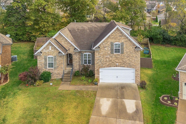 view of front of house featuring brick siding, a shingled roof, an attached garage, a front yard, and driveway