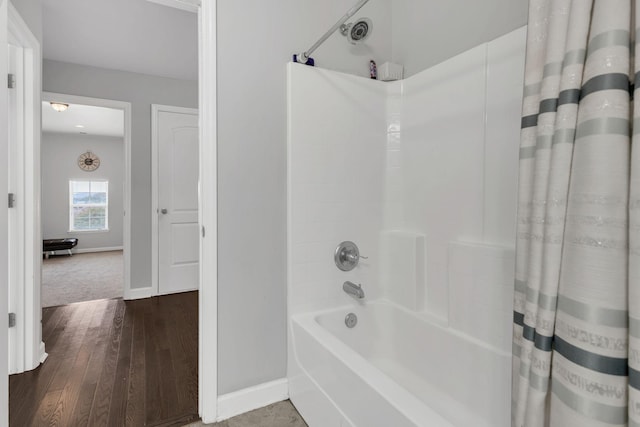 full bath with baseboards, shower / bath combo with shower curtain, and wood finished floors