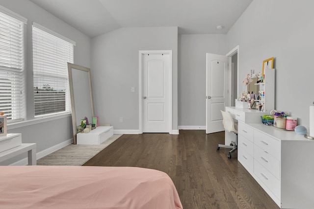 bedroom featuring lofted ceiling, dark wood-type flooring, built in study area, and baseboards