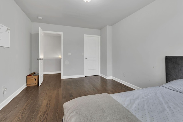 bedroom featuring dark wood-type flooring and baseboards