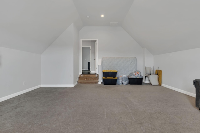 additional living space featuring baseboards, vaulted ceiling, and carpet flooring