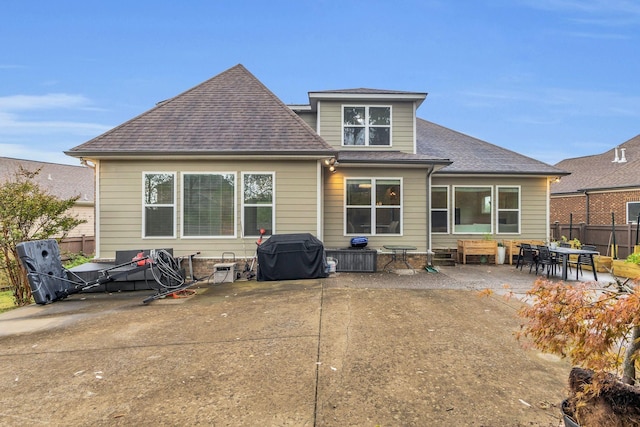 back of house with roof with shingles, fence, and a patio