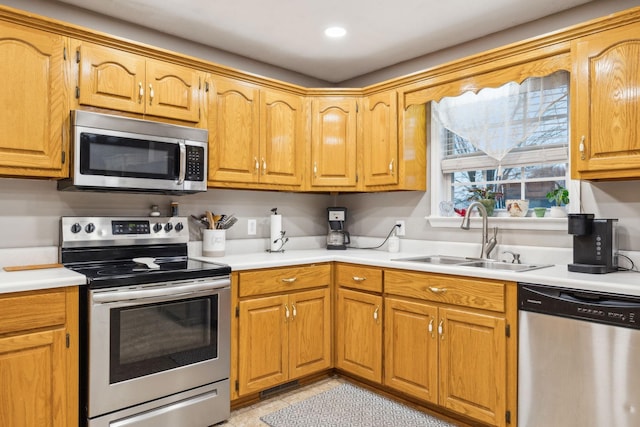 kitchen featuring stainless steel appliances, light countertops, a sink, and light tile patterned floors